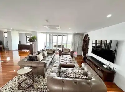 Luxurious living room with elegant leather sofas and large TV, perfect for entertaining.