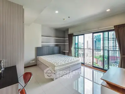 Spacious bedroom with city view and modern furnishings in high-rise apartment