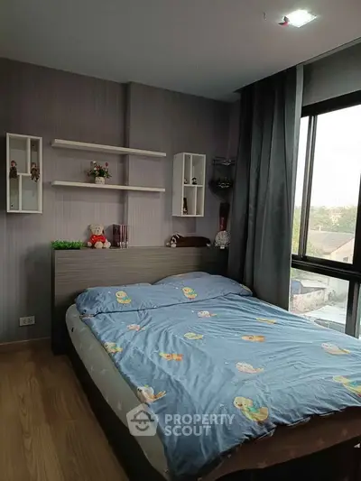 Cozy bedroom with large window and modern decor in a stylish apartment.