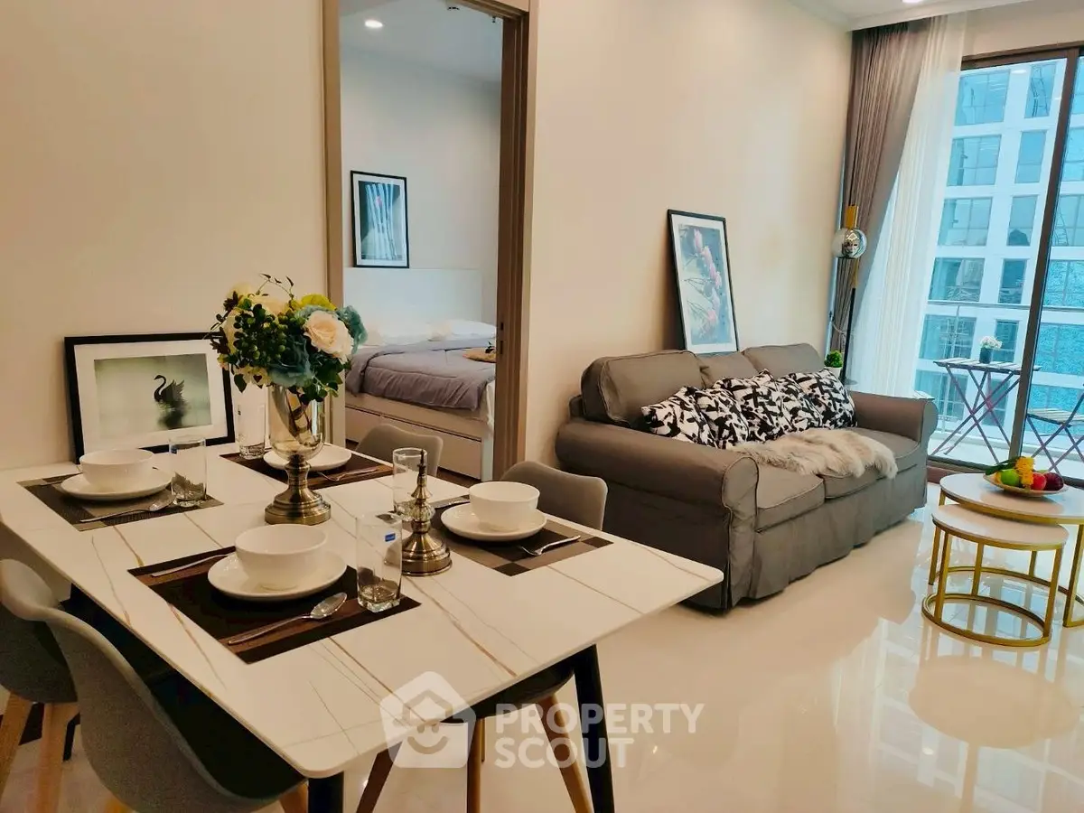 Modern open-plan living room with stylish dining area and cozy sofa, featuring elegant decor and natural light.