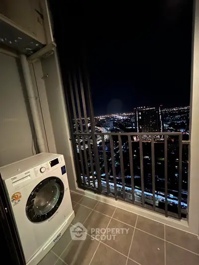 High-rise balcony with city night view and washing machine.