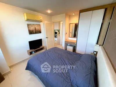 Modern bedroom with sleek design, featuring a cozy bed, wall-mounted TV, and stylish decor.