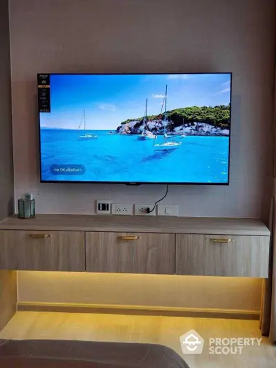 Modern living room with wall-mounted flat-screen TV and sleek wooden console, ambient lighting enhancing the cozy atmosphere.