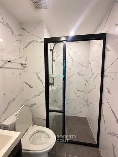Modern bathroom with marble tiles and glass shower enclosure
