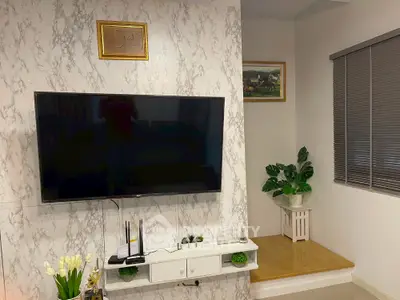 Modern living room with marble accent wall and large flat-screen TV