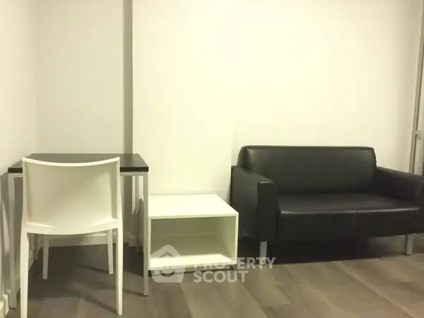 Minimalist living room with black sofa and white furniture