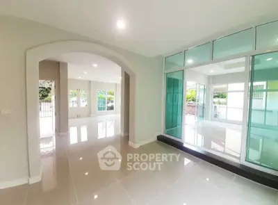 Spacious modern living room with glossy tiled floors and large windows
