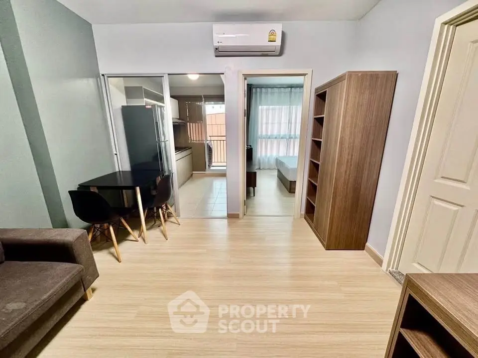 Modern apartment interior with open layout, featuring a cozy living area, dining space, and visible bedroom.