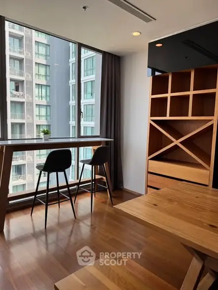 Modern apartment with stylish wooden furniture and large windows offering city views.