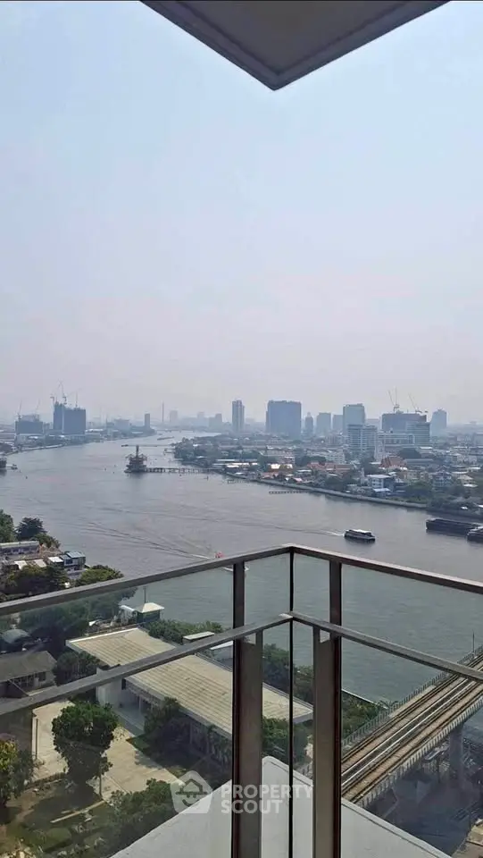 Stunning river view from a high-rise balcony in the city, showcasing urban skyline and serene waters.