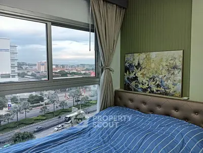 Cozy bedroom with large window offering stunning city view