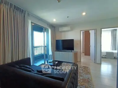Spacious living room with modern decor and balcony access in a stylish apartment.