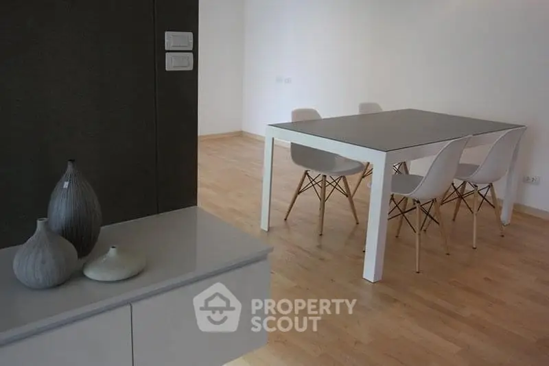 Modern dining area with sleek table and chairs on wooden flooring