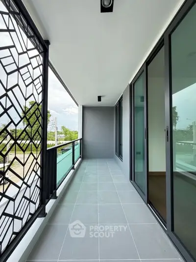 Spacious modern balcony with stylish railing and glass doors, perfect for relaxation and outdoor enjoyment.
