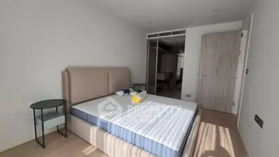 Spacious bedroom with modern design and ample natural light, featuring a comfortable bed and stylish side tables.