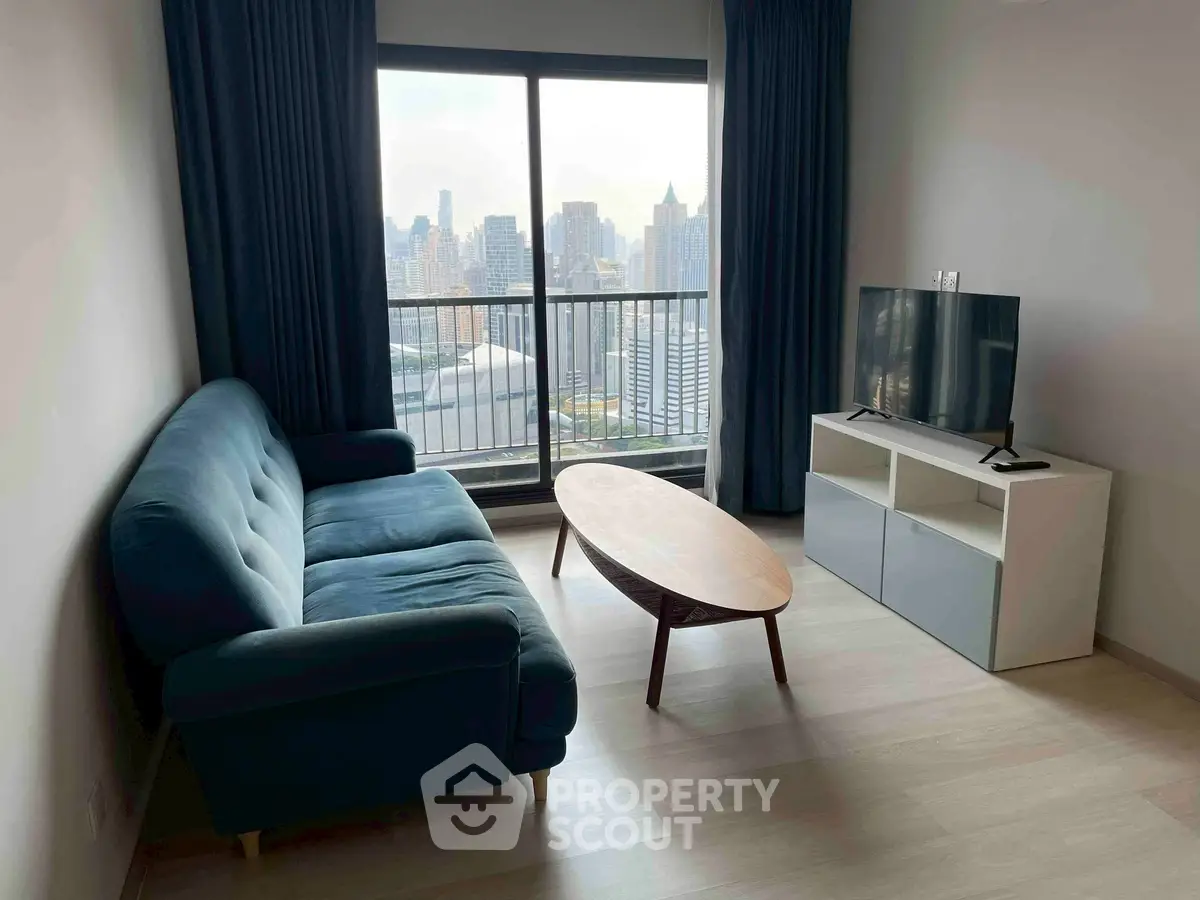 Modern living room with city view, featuring a stylish sofa and sleek TV setup.