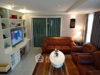 Cozy living room with leather sofas and built-in shelves, perfect for relaxation.