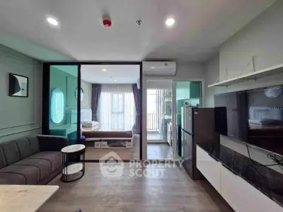 Modern open-plan living room with glass partition, stylish furniture, and natural light.