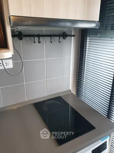 Modern kitchen with sleek electric cooktop and stylish backsplash tiles