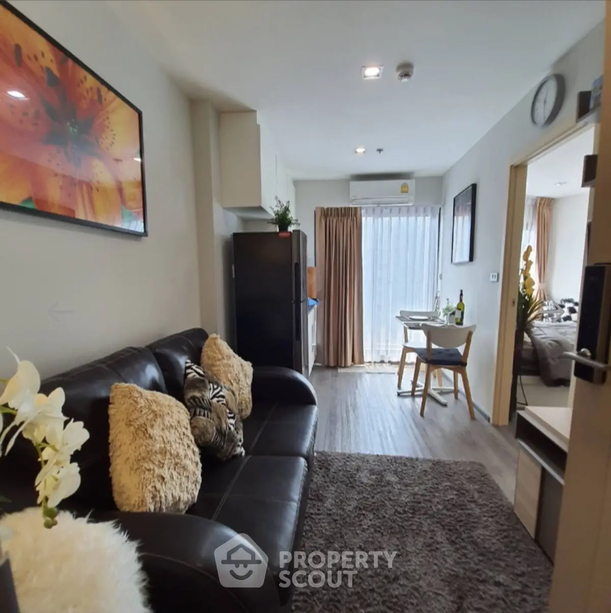 Modern living room with cozy decor and dining area, featuring stylish furniture and natural light.