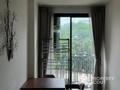 Cozy dining area with balcony view and modern decor in urban apartment.