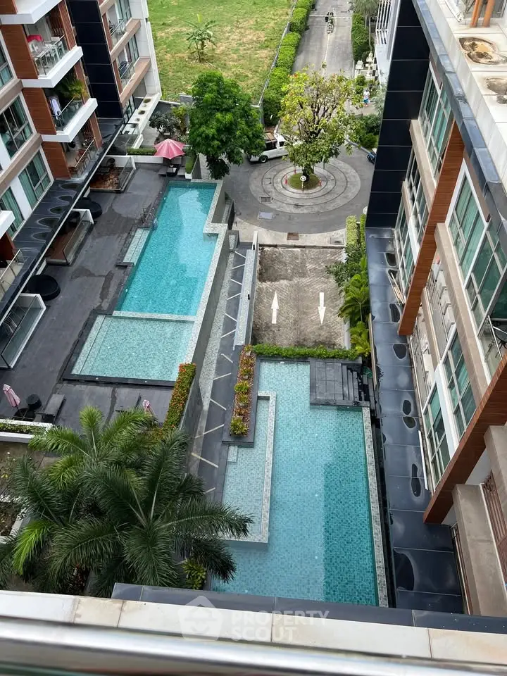 Luxurious apartment complex with stunning multi-level swimming pools and lush greenery.