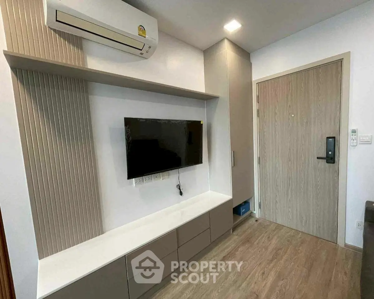 Modern living room with wall-mounted TV and air conditioning unit.