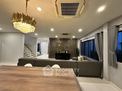 Luxurious modern living room with elegant chandelier and spacious seating area.