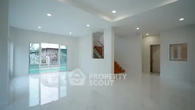 Spacious modern living room with elegant staircase and large windows