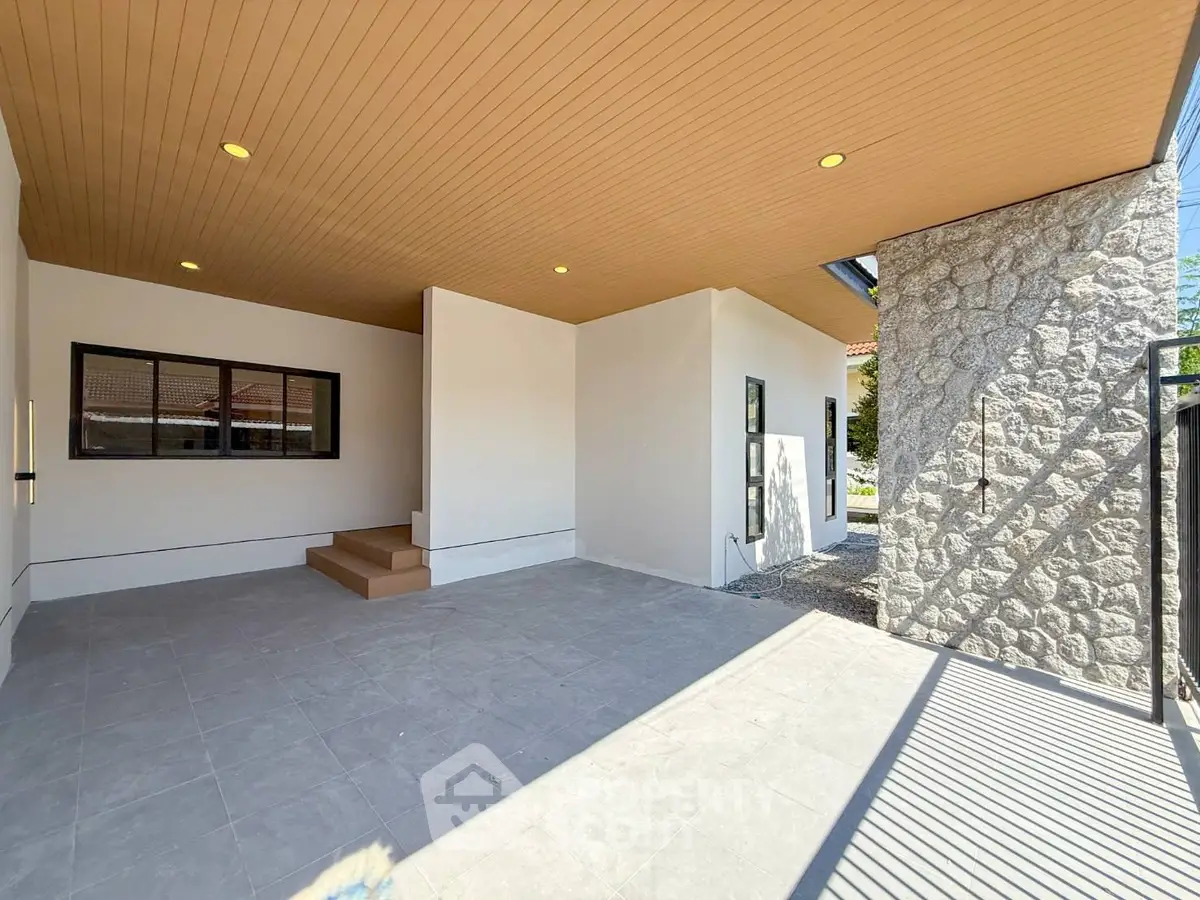 Spacious modern home exterior with stone accents and covered patio area.