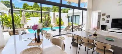 Luxurious open-plan living room with pool view and modern decor