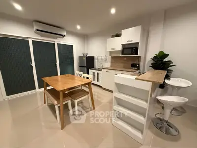 Modern kitchen with open layout, sleek cabinetry, and dining area in stylish apartment.