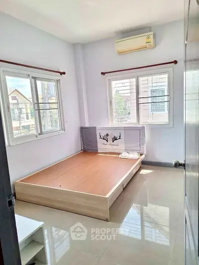 Bright bedroom with large windows and air conditioning in modern home.