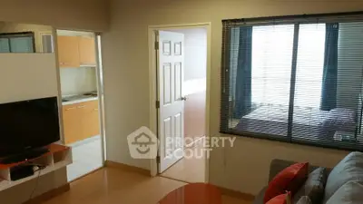 Modern apartment interior with cozy living room, kitchen, and bedroom view.