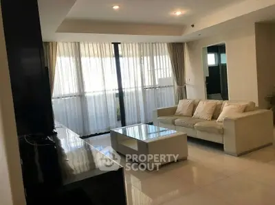 Spacious modern living room with elegant decor and large windows.