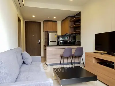 Modern open-plan living room with kitchen, featuring sleek furniture and contemporary design.