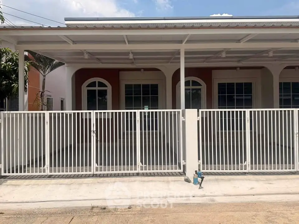 Charming single-story home with gated entrance and covered parking area, perfect for modern living.