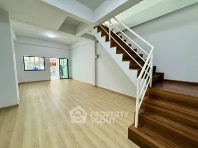 Spacious modern living room with wooden staircase and large windows