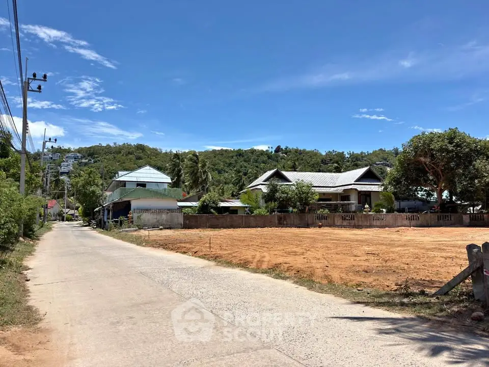 Scenic view of residential area with houses and open land under clear blue sky.