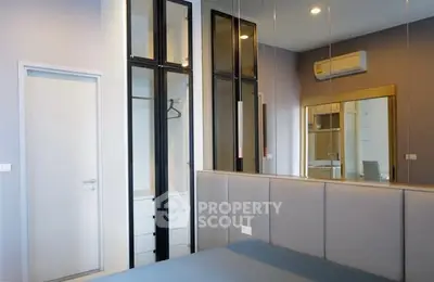 Modern bedroom with sleek mirrored wardrobe and air conditioning