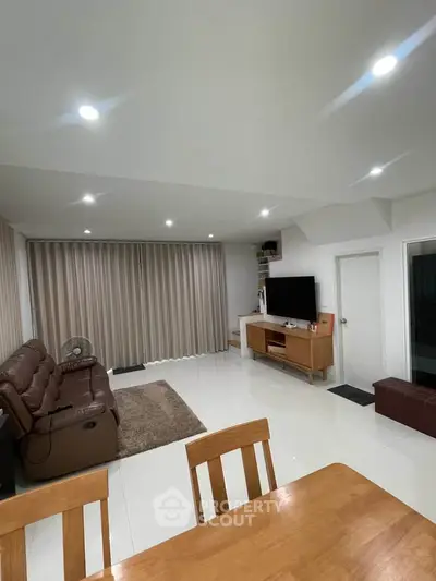 Spacious living room with modern furniture and natural lighting, perfect for relaxation and entertainment.