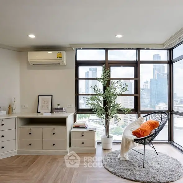 Modern living room with city view, stylish chair, and natural light.