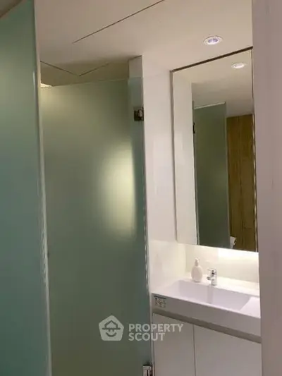Modern bathroom with frosted glass shower and sleek vanity
