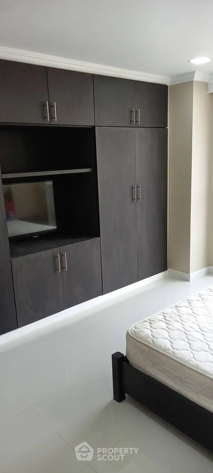 Spacious bedroom with built-in wardrobe and sleek flooring