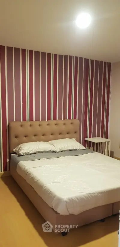 Cozy bedroom with stylish striped wallpaper and comfortable bed