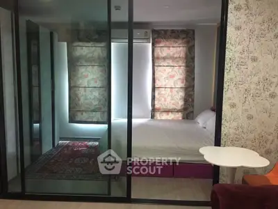 Modern bedroom with glass partition and stylish decor in a cozy apartment.