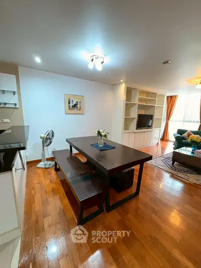 Spacious open-plan living and dining area with modern furnishings and wooden flooring.