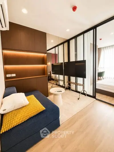 Modern living room with stylish decor and open layout, featuring a cozy sofa and elegant lighting.