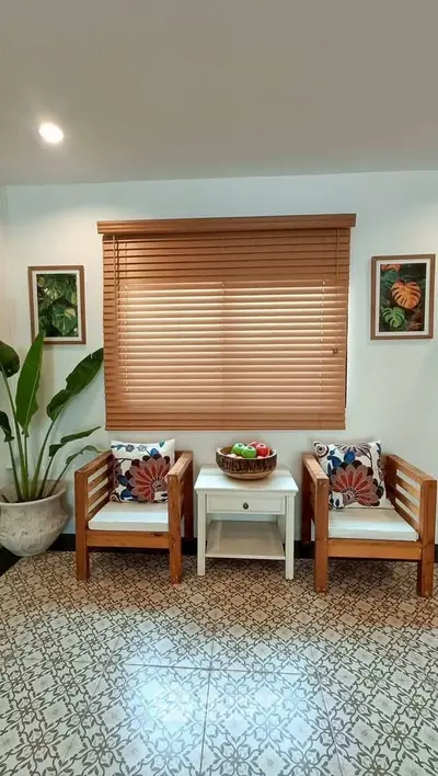 Charming sitting area with wooden chairs and decorative pillows in cozy home interior.