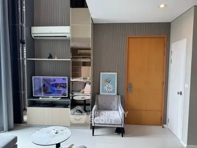 Modern living room with stylish decor and open layout, featuring a TV and air conditioning unit.